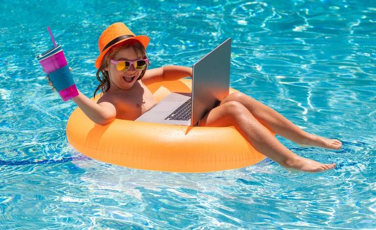 Kleines Mädchen entspannt sich im Pool mit Laptop, Schwimmreifen und einem Getränk.