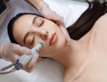 Eine Frau erhält eine professionelle Hydrafacial Behandlung im Kosmetikstudio, bei der ihre Haut sanft gereinigt und gepflegt wird