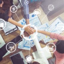 Gruppenmeeting mit digitalen Symbolen, das Teamarbeit und den Einsatz der ERP-Software Sage zur Verbesserung von Geschäftsprozessen darstellt