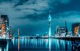 Beleuchtete moderne Architektur in Düsseldorf mit reflektierendem Wasser.