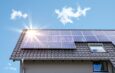 Photovoltaikanlage Krefeld auf einem Schrägdach bei blauem Himmel mit Sonnenreflexion auf den Solarmodulen
