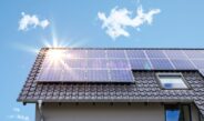 Photovoltaikanlage Krefeld auf einem Schrägdach bei blauem Himmel mit Sonnenreflexion auf den Solarmodulen