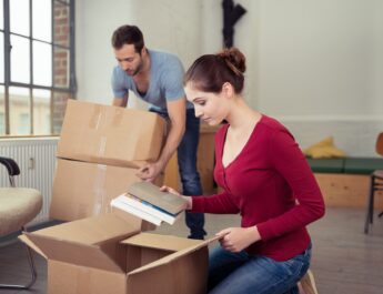 Paar packt persoenliche Dinge fuer Wohnungswechsel ein | Haushaltsauflösung Kosten
