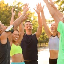 Sportgruppe jubelt nach Training im Park | Sportmediziner Köln