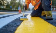 Arbeiter zieht gelbe Linie auf Straße | Straßenmarkierung