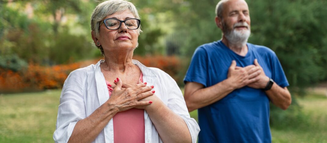 Älteres Paar übt Achtsamkeit und tiefe Atmung im Garten | finnische Sauna
