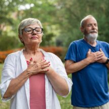 Älteres Paar übt Achtsamkeit und tiefe Atmung im Garten | finnische Sauna