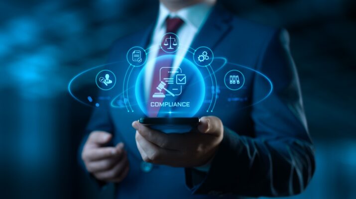 Geschäftsmann hält digitales Compliance-Symbol | Anwalt für Produkthaftung